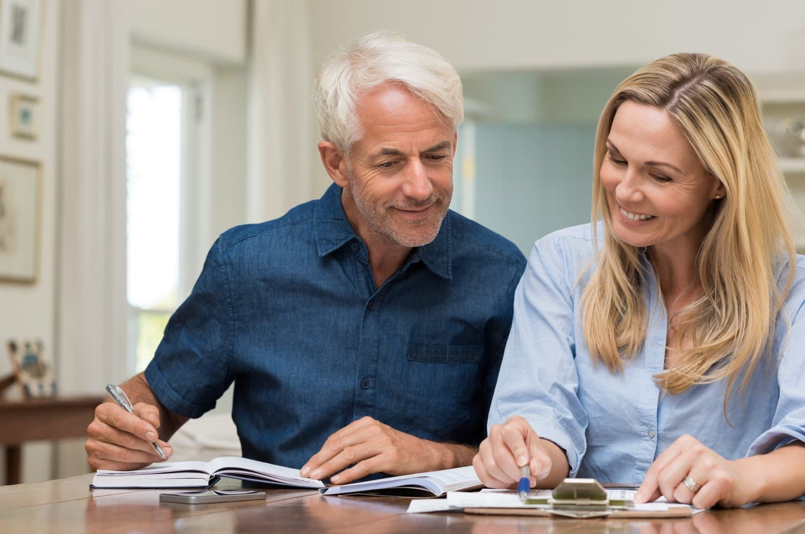 A couple going over paperwork together at their kitchen table